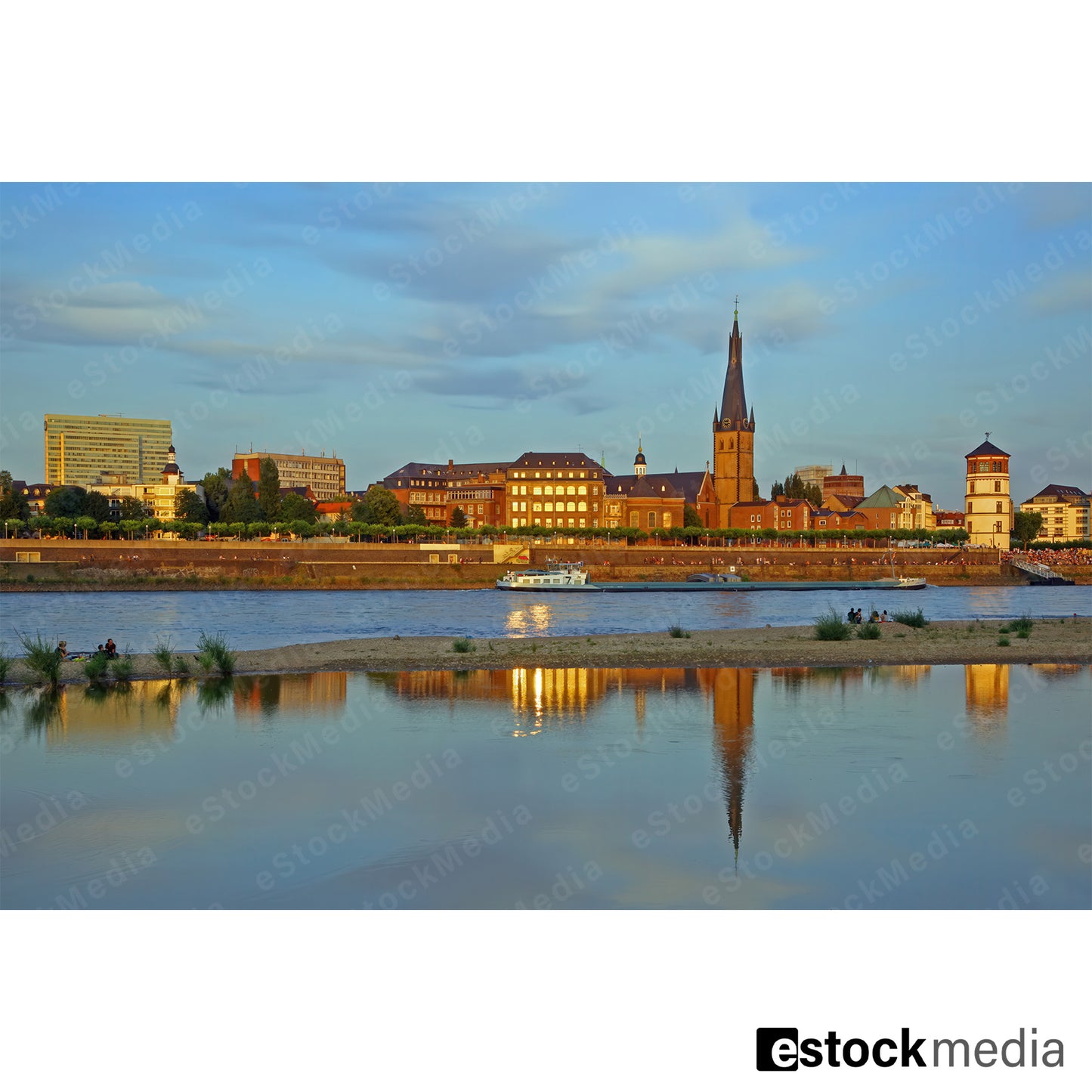 Düsseldorf riverfront at sunset with reflections on the Rhine River.